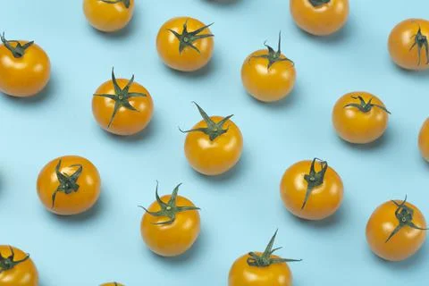 Cherry tomatoes on a colored blue background. Pattern and minimal background  Stock Photos