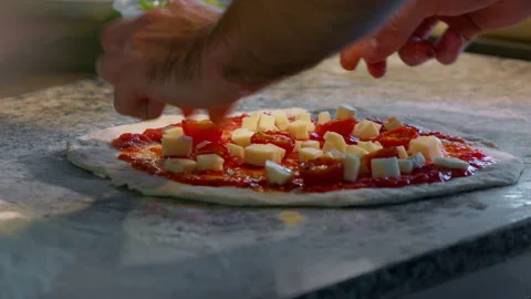 Cherry tomatoes, cut in half, are spread over the surface of the pizza Stock Footage 159338004