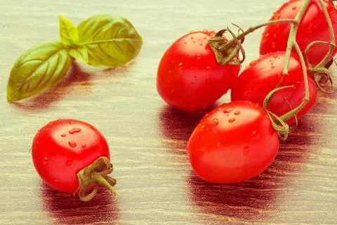 Cherry tomatoes on a dark table. Retro effect. Stock Photos