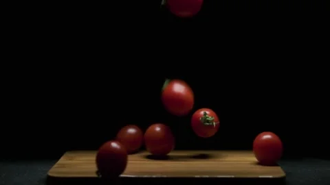 Cherry tomatoes fall on the board. Slow motion Stock Footage 300678247
