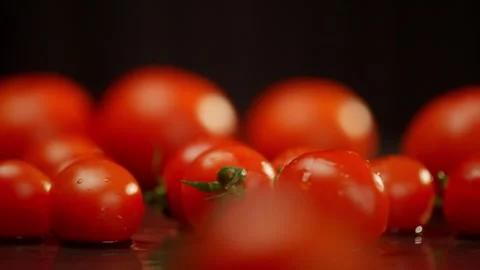 Cherry tomatoes fall one by one on a dark surface. Stock-Footage 271264098
