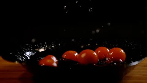 Cherry tomatoes falling on a black plate, Ultra Slow Motion Stock Footage 86575829