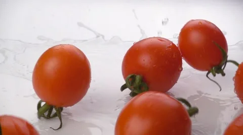 Cherry tomatoes falling on white background. With water splash Stock Footage 60413991