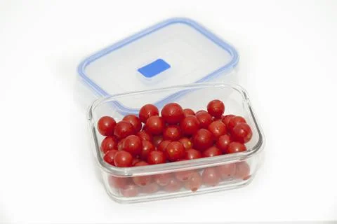 Cherry tomatoes in glass container on white background Stock Photos