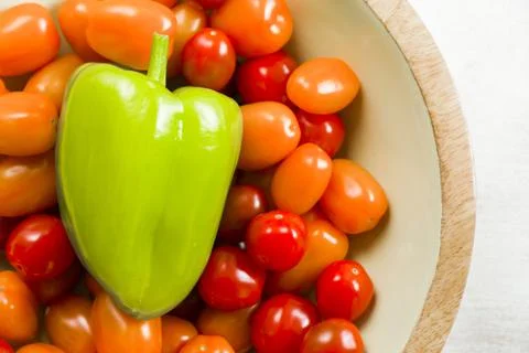 Cherry tomatoes, green bell pepper on the white background Stock Photos