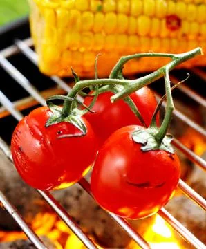 Cherry tomatoes grilling over a fire Stock Photos
