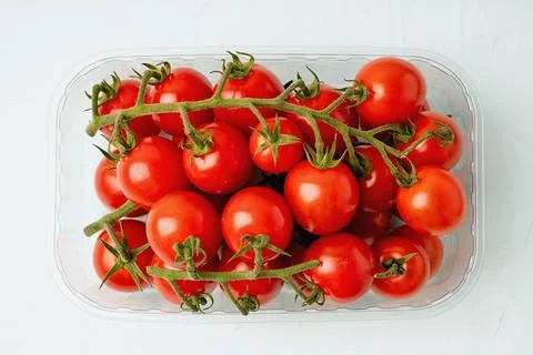 Cherry tomatoes in plastic container isolated Stock Photos