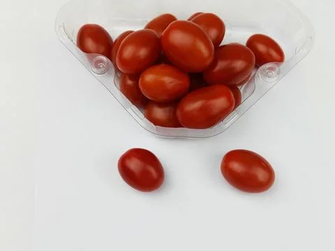 Cherry tomatoes in plastic container on white background Stock Photos