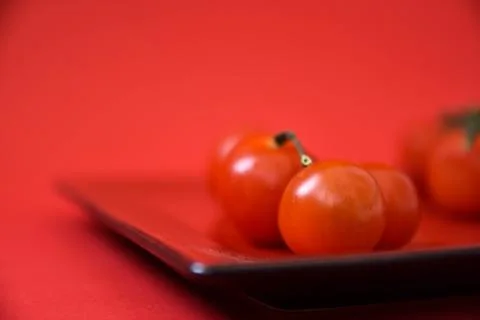 Cherry tomatoes on a red plate. Stock Photos