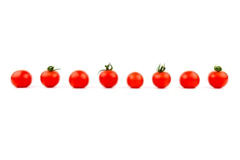 Cherry tomatoes in a row on a white background. Stock Photos