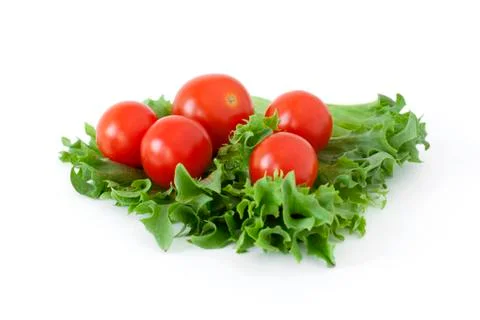Cherry tomatoes on a salad leaf on white background Stock Photos