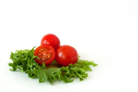 Cherry tomatoes on a salad leaf on white background Stock Photos