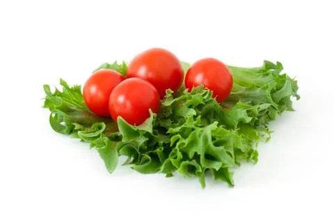 Cherry tomatoes on a salad leaf on white background Stock Photos