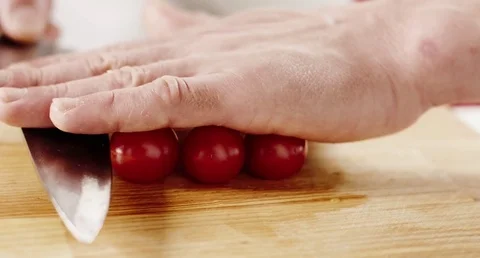 Cherry tomatoes scliced by chief's hands with big knife 库存影片 73177681