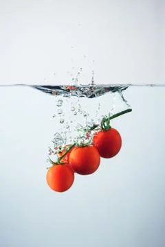 Cherry tomatoes splash Stock Photos