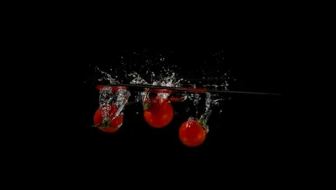 Cherry tomatoes splashed into water 写真素材