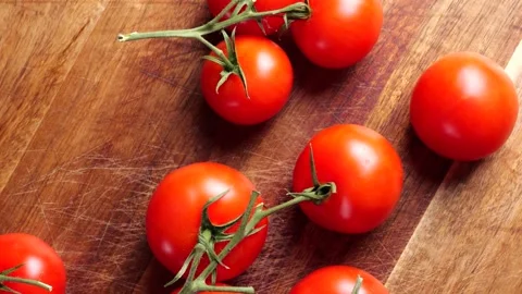 Cherry tomatoes stop motion animation on wooden cutting board Stock Footage 305809890