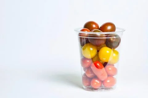 Cherry tomatoes in transparent plastic box on white background Stock Photos