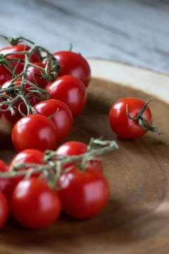 Cherry tomatoes on the vine in rustic setting Foto stock