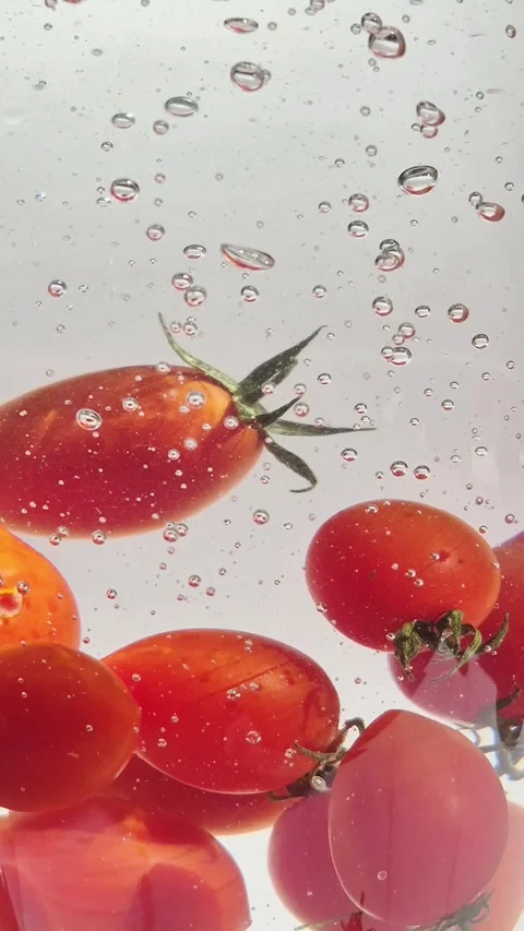 Cherry tomatoes in water in motion close-up on a light background Video stock 309998989