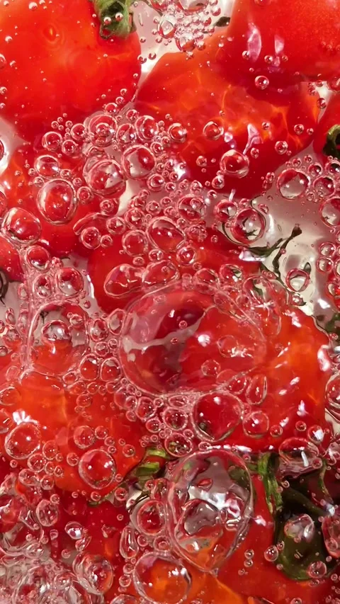 Cherry tomatoes in water in motion close-up on a light background Stock Footage 309999033