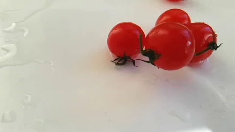 Cherry tomatoes wet on white background, slow motion Stock Footage 89711783