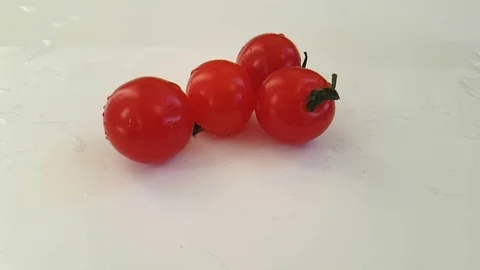 Cherry tomatoes wet on a white background, slow motion, motion water Stock Footage 89712807