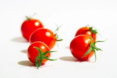 Cherry tomatoes on a white background are arranged randomly.selective focus. Stock Photos