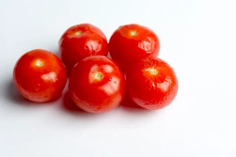 The cherry tomatoes on a white background. Stock Photos
