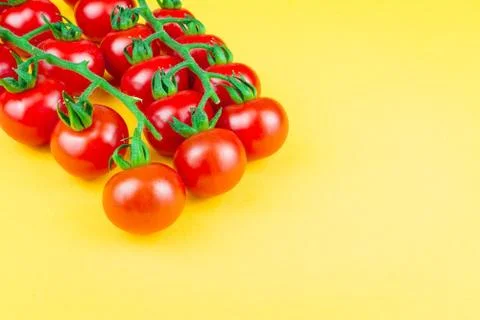 Cherry tomatoes on yellow background Stock Photos