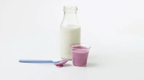 Cherry yoghurt in pot, spoon and a bottle of milk Stock Footage 8571865
