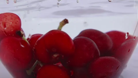 Cherrys falling with water drops. Slow motion. Stock Footage 276947618