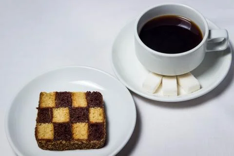 Chess baking and a cup of coffee on a white tablecloth. Stock Photos