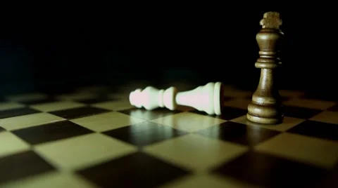 A chess board with a black background, a black king throws down the white king 스톡 동영상 58412641