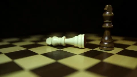 A chess board with a black background, a black king throws down the white king 스톡 동영상 58419572