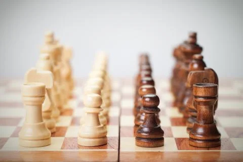 Chess board with figures on grey background Stock Photos