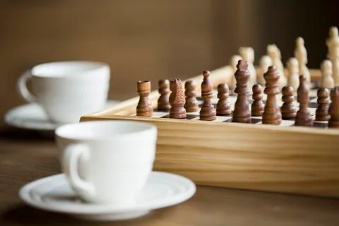 Chess board game with two coffee cups beside Stock Photos