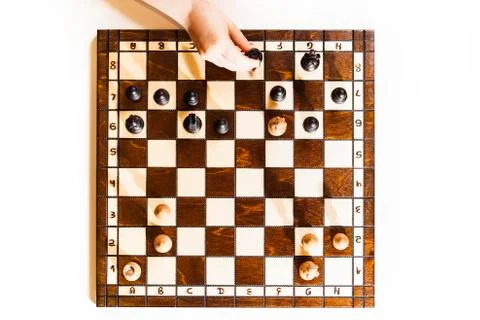 Chess board on white background. Little caucasian girl holding a black castle Stock Photos