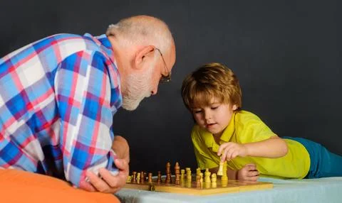 Chess competition. Cute boy thinking about next move in game of chess. Gran.. Stock Photos