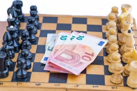 Chess components and money between them Stock Photos