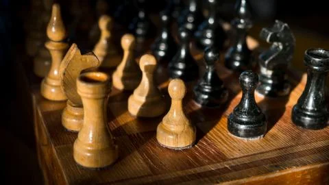 Chess is a confrontation on a dark background Stock Photos