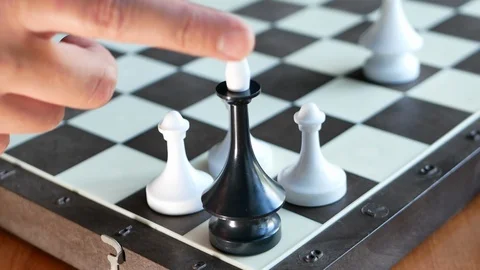 Chess figure black king is falling being surrounded by three white pawns Vidéo 116057981