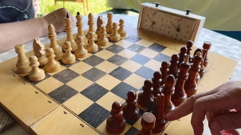 Chess game board closeup. Senior men hand moving figure in strategy game Stock Footage 248667599