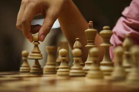 On a chess game, a chess player makes a move with a pawn Stock Photos
