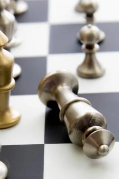 Chess game - fallen silver king on chessboard Stock Photos