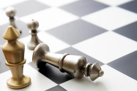 Chess game - fallen silver king on chessboard Stock Photos