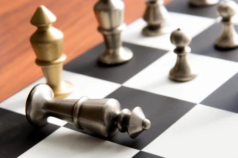 Chess game - fallen silver king on chessboard Stock Photos