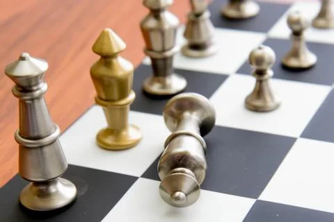Chess game - fallen silver king on chessboard Stock Photos