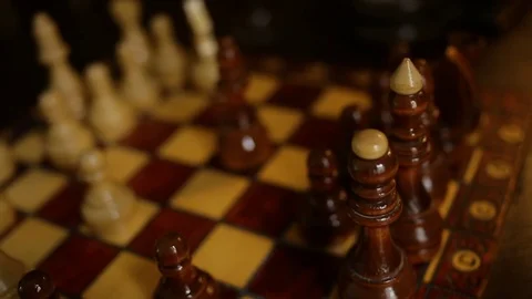 Chess game, player makes a move the white Bishop pieces on the board Man plays Stock Footage