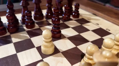 Chess game in progress with wooden pieces highlighted on a classic board Stock Footage 308011894